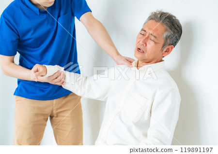 護理人員為一名老人檢查肩部疼痛 119891197