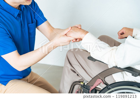 護理人員攙扶著一位坐在輪椅上的老人 護理人員攙扶著一位坐在輪椅上的老人 119891213