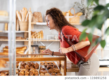 Curious woman choosing baked goods 119891258