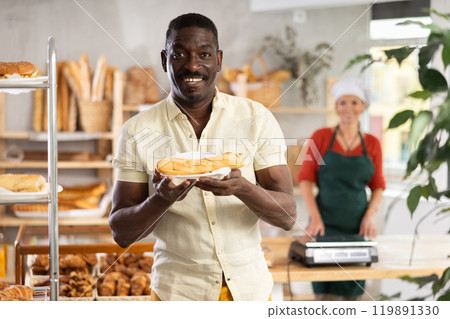 Cheerful man with fresh sandwich in bakery 119891330