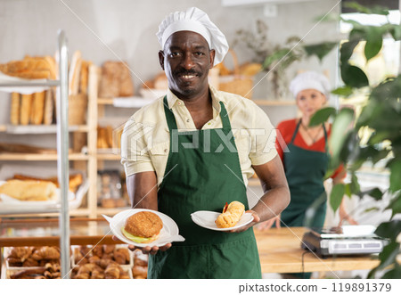 Smiling male baker with pastry in bakehouse 119891379