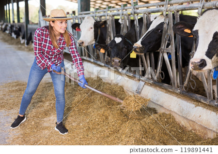Portrait of female employee working in cowshed on farm 119891441