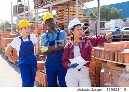 Three workers are discussing work issues at the warehouse 119891449