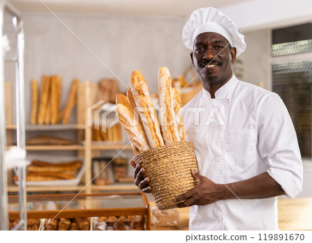 Male baker with basket of fresh baguettes Male baker with basket of fresh baguettes 119891670