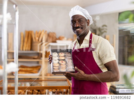 Portrait of positive man bakery worker with cookies 119891682