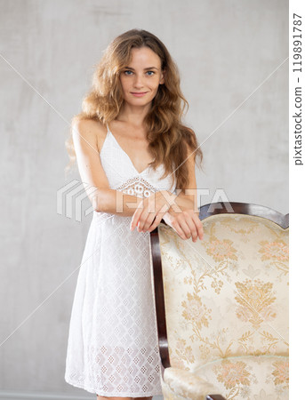 Young woman posing with chair in studio 119891787