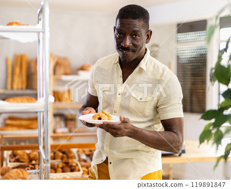 African man customer holding disposable plate with burger in bakery 119891847