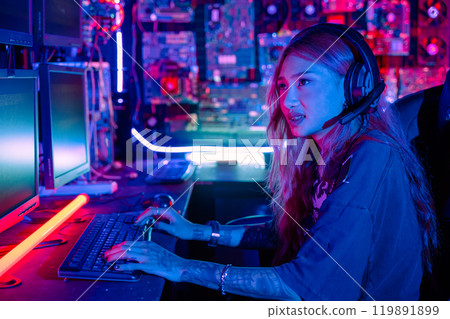 Woman hacker sitting in front of a computer typing on keyboard hacking servers in neon light, Female hacker breaks into data center, Gamer woman streaming game online in a dark room Woman hacker sitting in front of a computer typing on keyboard hacking servers in neon light, Female hacker breaks into data center, Gamer woman streaming game online in a dark room 119891899