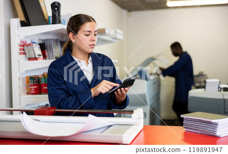 Female employee of printing house counts the cost of work on calculator Female employee of printing house counts the cost of work on calculator 119891947