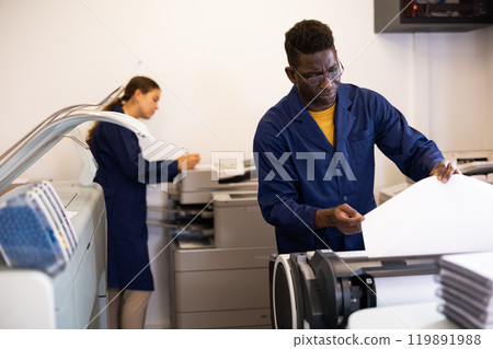 Attentive african american man uses plotter in printing shop 119891988