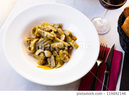 Plate of tasty cooked artichokes with sea shellfish 119892146