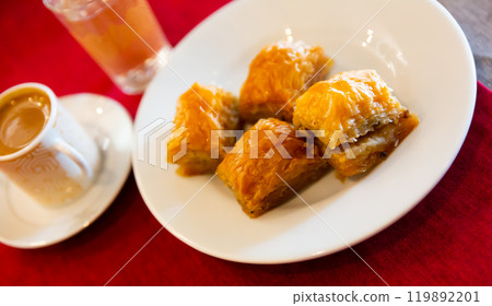 Traditional Turkish dessert - baklava on a plate and cup of coffee Traditional Turkish dessert - baklava on a plate and cup of coffee 119892201