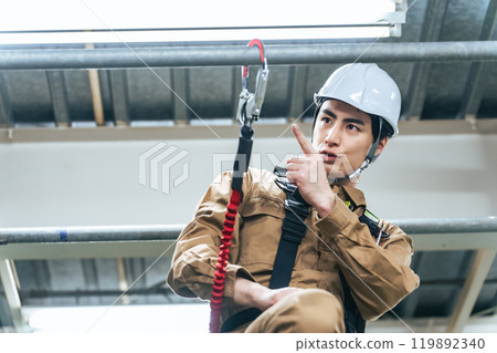 工人爬上建築工地鷹架檢查防墜鉤 工人爬上建築工地鷹架檢查防墜鉤 119892340