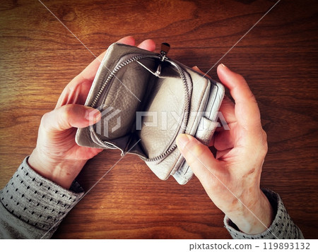 老婦人的手打開桌上的空錢包 老婦人的手打開桌上的空錢包 119893132