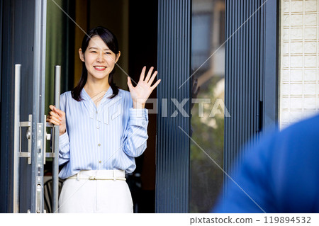 Couple waving at the front door 119894532