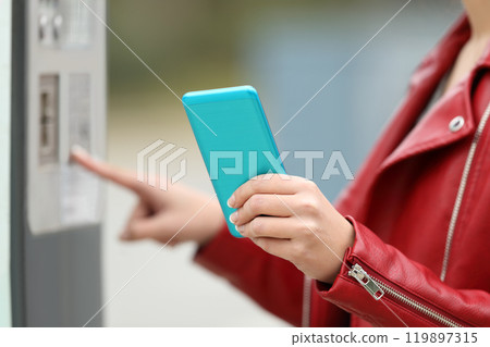 Girl using a smart phone to pay in a payment machine 119897315