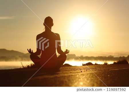Silhouette of a fitness woman exercising yoga meditation exercises 119897392