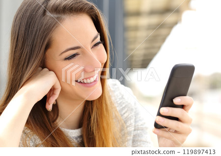 Woman browsing media in a mobile phone Woman browsing media in a mobile phone 119897413