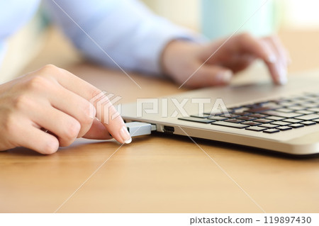 Woman hand connecting a pendrive in a laptop 119897430