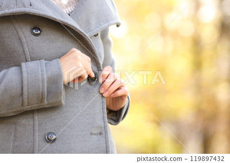 Woman hand fastening a button on the jacket in winter Woman hand fastening a button on the jacket in winter 119897432