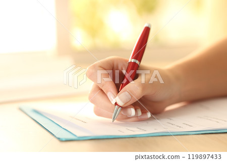 Woman hand filling form on a table 119897433