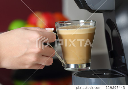 Woman hand holding a cup in a coffee maker Woman hand holding a cup in a coffee maker 119897443