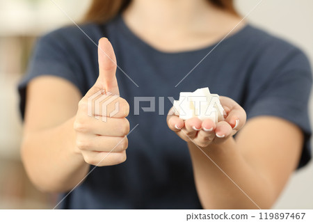 Woman hand holding sugar cubes with thumbs up 119897467