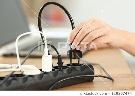 Woman hand plugging a plug in an electrical socket 119897474