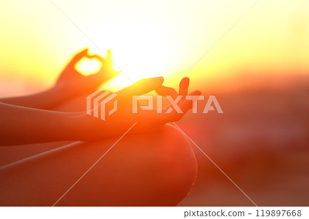 Woman hands doing yoga relaxing at sunset outdoor 119897668
