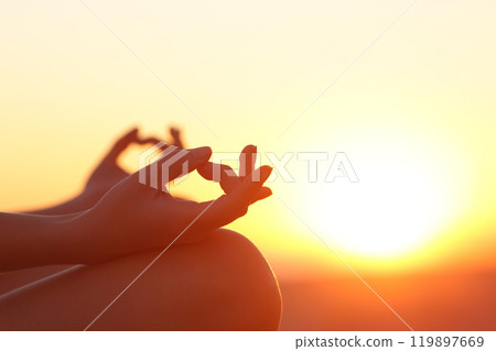 Woman hands exercising yoga at sunset Woman hands exercising yoga at sunset 119897669