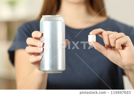 Woman hands holding a soda drink can and a sugar cube Woman hands holding a soda drink can and a sugar cube 119897683