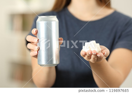 Woman hands holding a soda drink can and sugar cubes Woman hands holding a soda drink can and sugar cubes 119897685