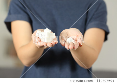 Woman hands holding sugar cubes and saccharin pills Woman hands holding sugar cubes and saccharin pills 119897694