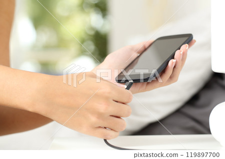 Woman hands plugging a charger in a smart phone 119897700