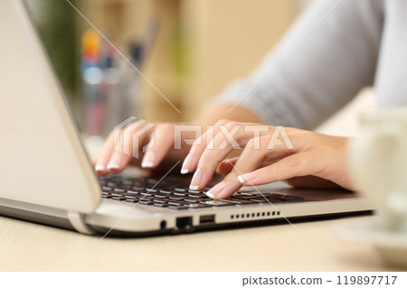 Woman hands types on laptop on a desk at home 119897717