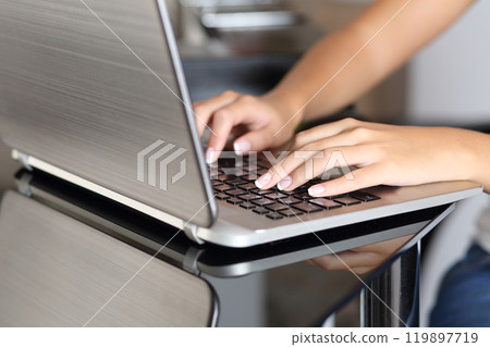 Woman hands typing in a laptop working at home 119897719