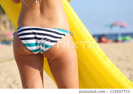 Woman in bikini on the beach with inflatable bed 119897753