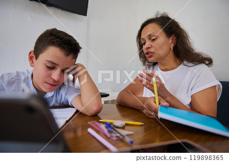 Focused tutoring session between student and teacher in casual setting 119898365