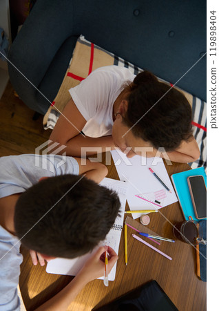 Two students collaborating on homework at a cozy study space 119898404