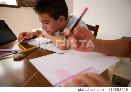 Focused young boy doing homework at the table Focused young boy doing homework at the table 119898426