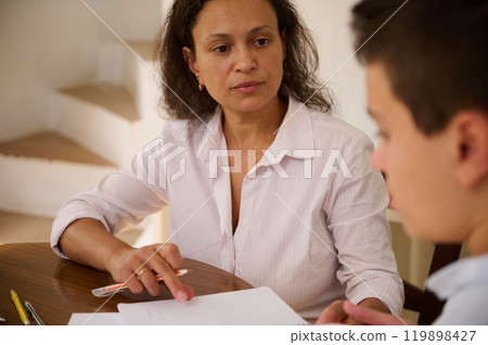 Mother and son discussing homework at the dining table 119898427