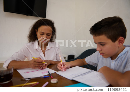 Mother and son engaged in focused study session at home Mother and son engaged in focused study session at home 119898431