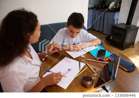 Mother and son engaged in focused study at home 119898446
