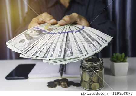Businessman holding cash for financial income. Banknotes in hands. Hand holding out money. 119898973