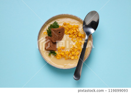 Corn soup in a plate, on a blue background. Corn soup in a plate, on a blue background. 119899093