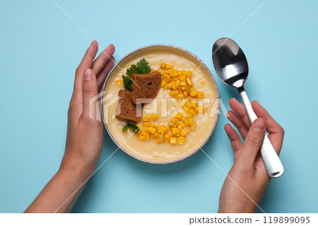 Corn soup in a plate, on a blue background. 119899095