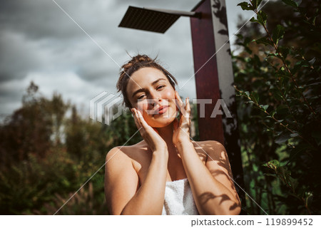 Beautiful woman touching her face, stainding outdoor in the garden. Woman taking care of her body and mind, wellness routine. Beautiful woman touching her face, stainding outdoor in the garden. Woman taking care of her body and mind, wellness routine. 119899452