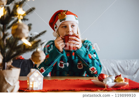 Young girl enjoying a warm drink in Christmas attire, embracing holiday spirit, festive cheer, seasonal traditions, cozy Christmas moment. Young girl enjoying a warm drink in Christmas attire, embracing holiday spirit, festive cheer, seasonal traditions, cozy Christmas moment. 119899910
