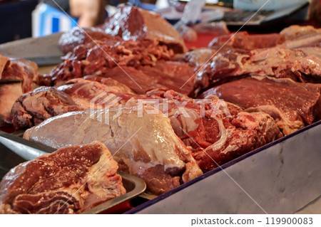 Close-up of cut pieces of meat on a table ready for sale. 119900083