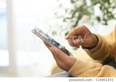 Close up of a woman checking messages and browsing on smartphone Close up of a woman checking messages and browsing on smartphone 119901355